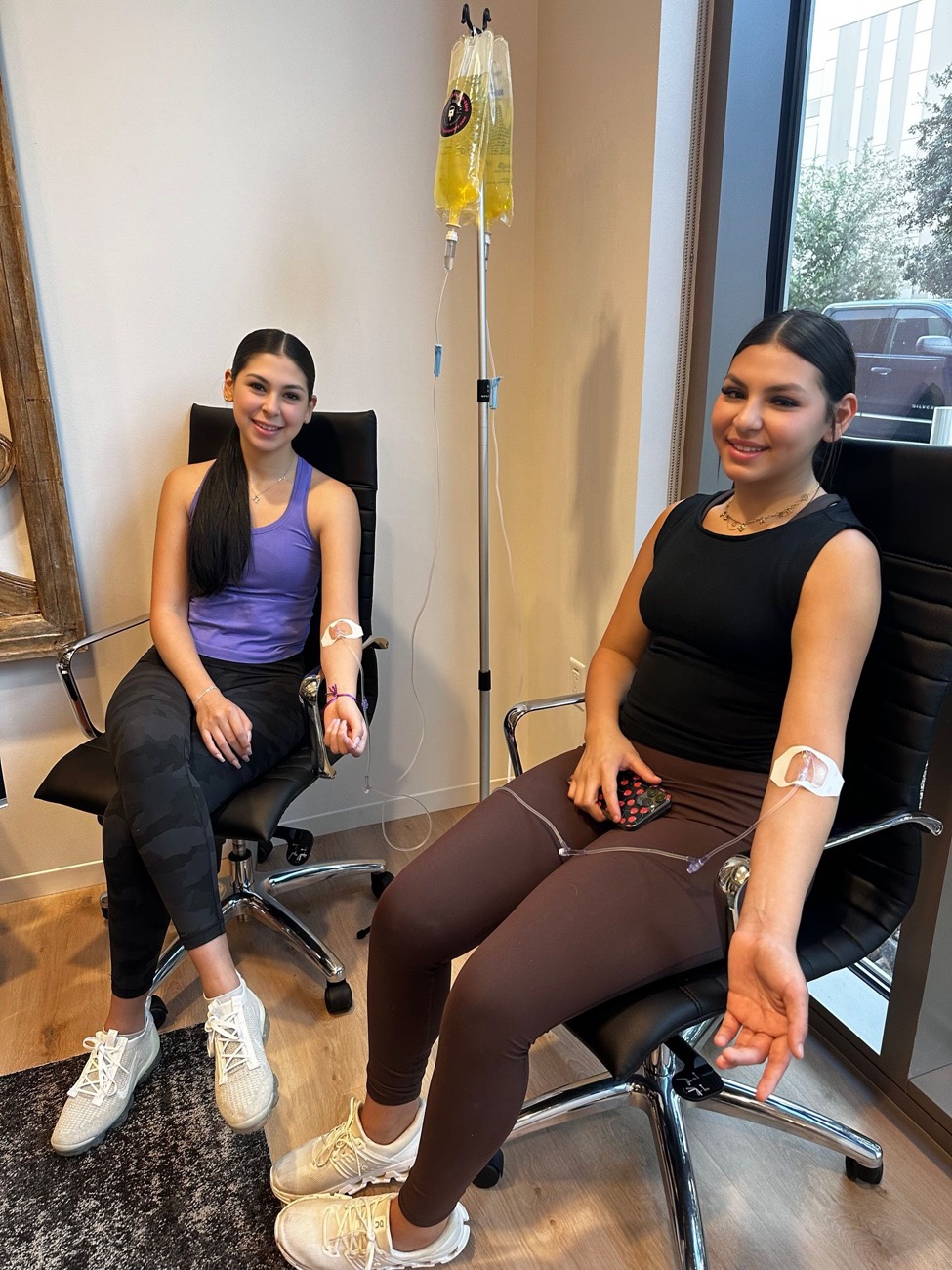 Two clients relaxing in chairs during their IVs