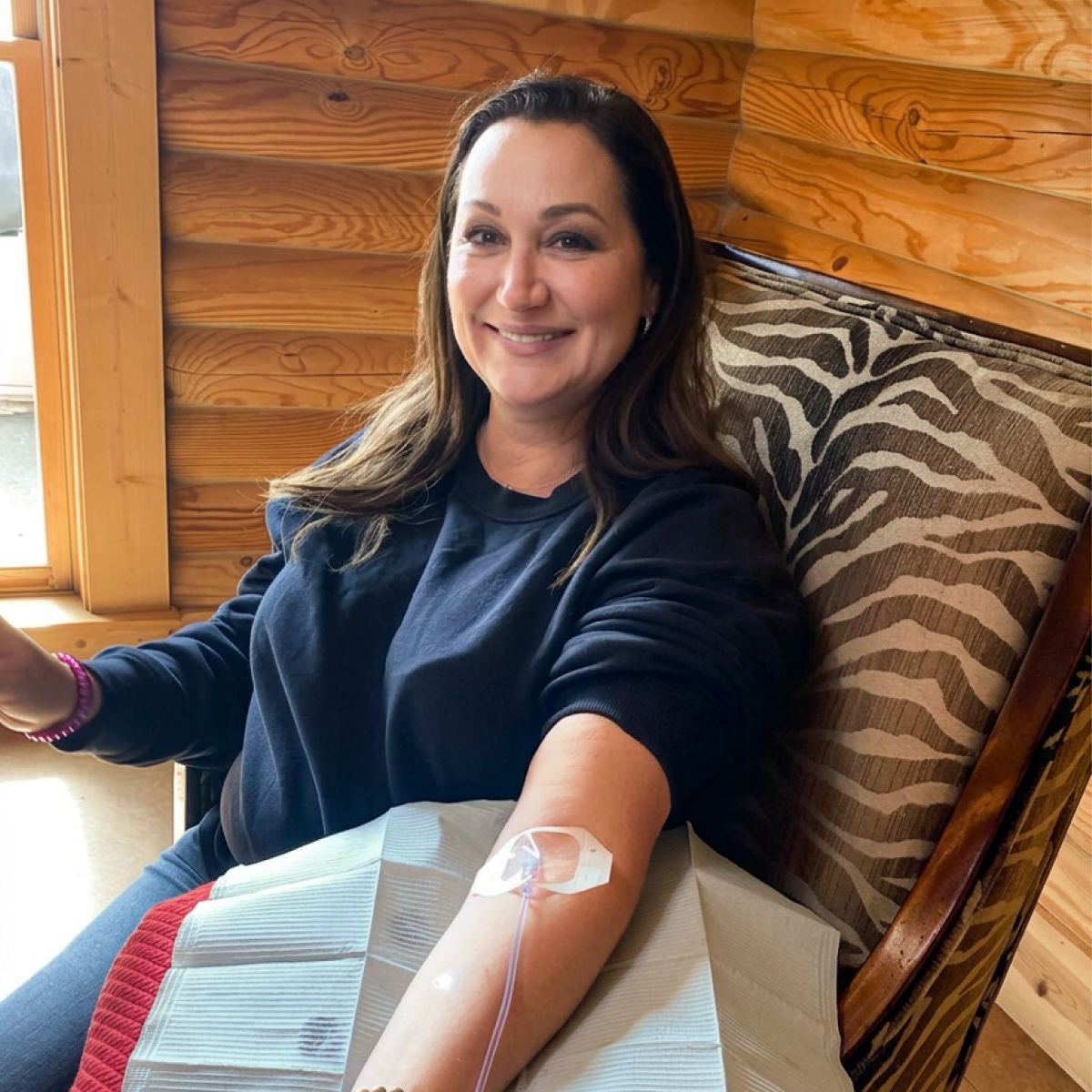 A client smiling in her armchair during an in-home IV