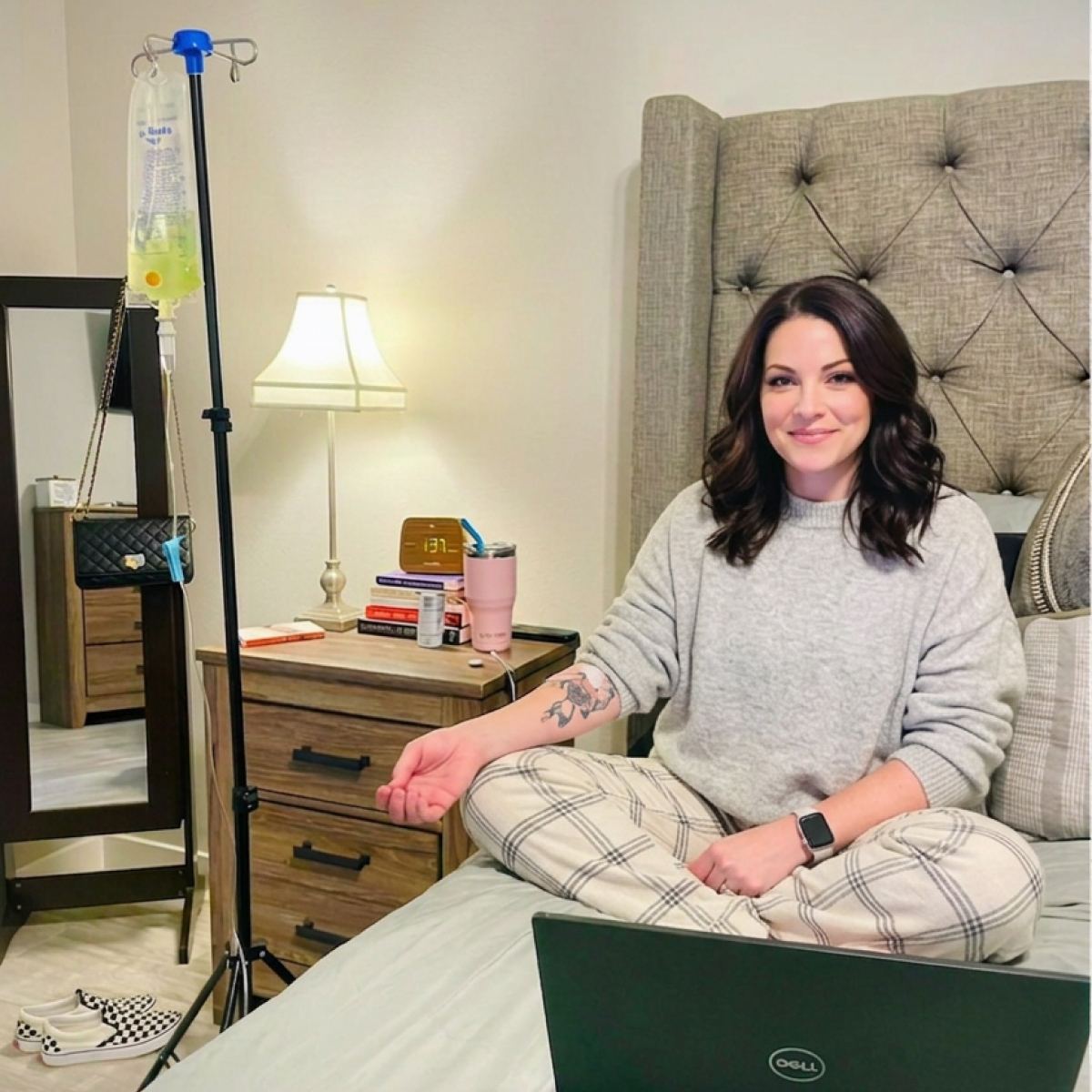 A client working on her laptop from bed during an in-home IV