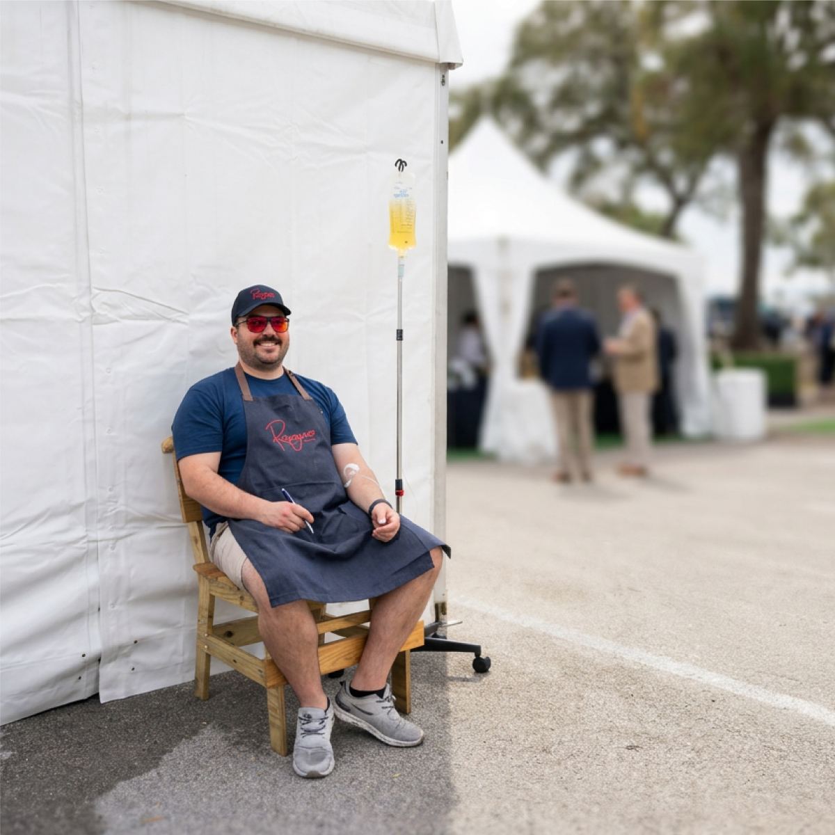 A client seated beside an event tent during his IV