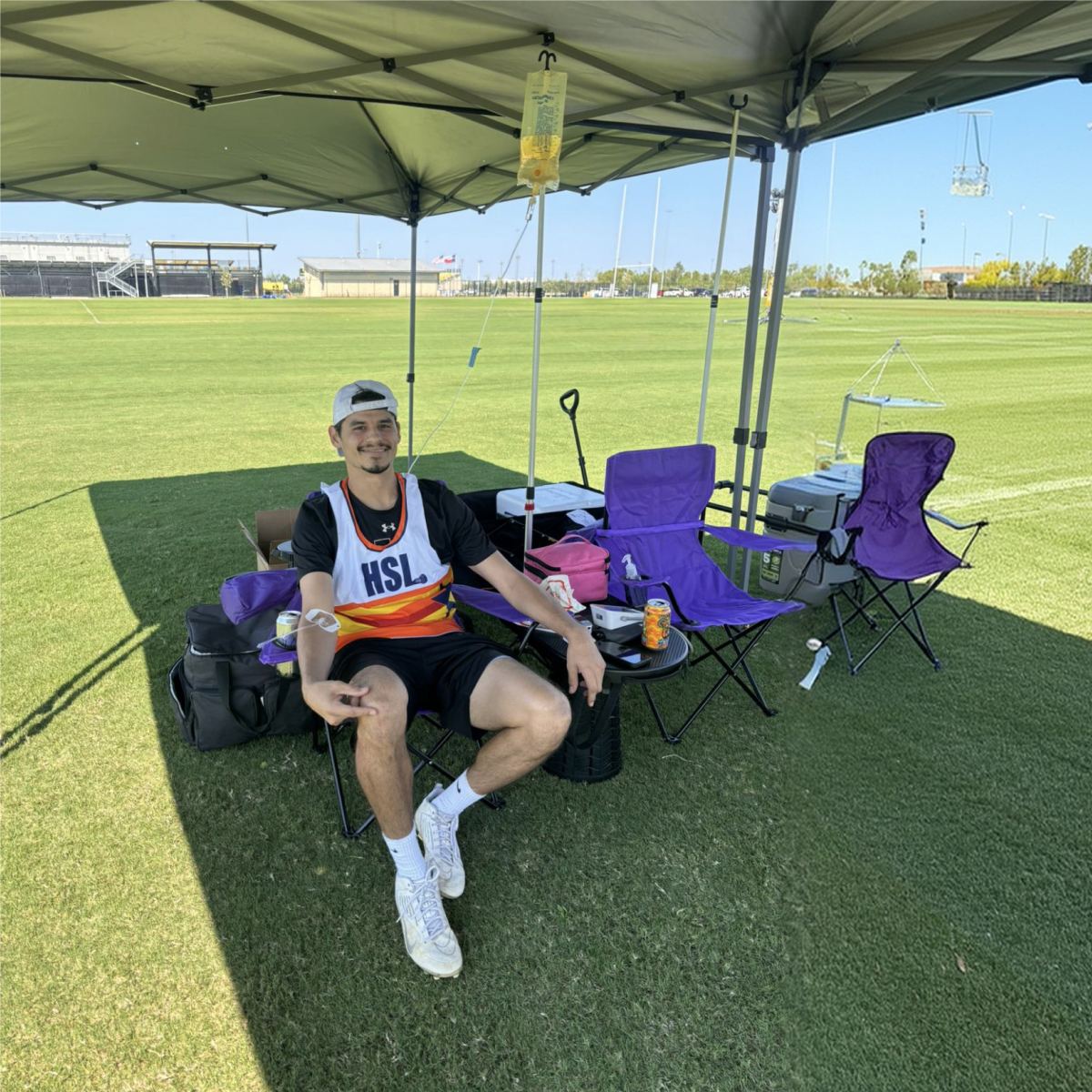 An athlete resting under a tent on the field during his IV