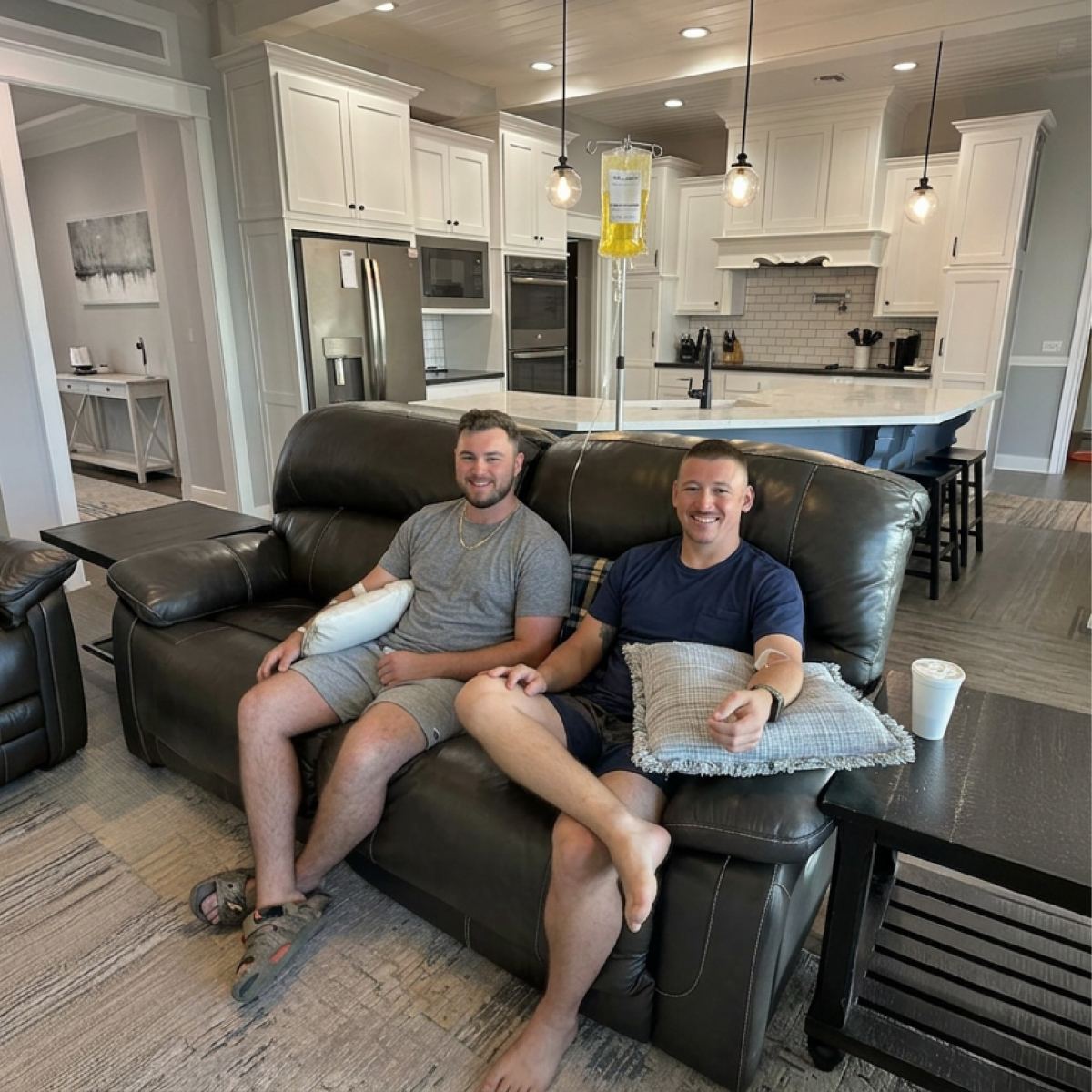 Two clients on a leather sofa during in-home IVs