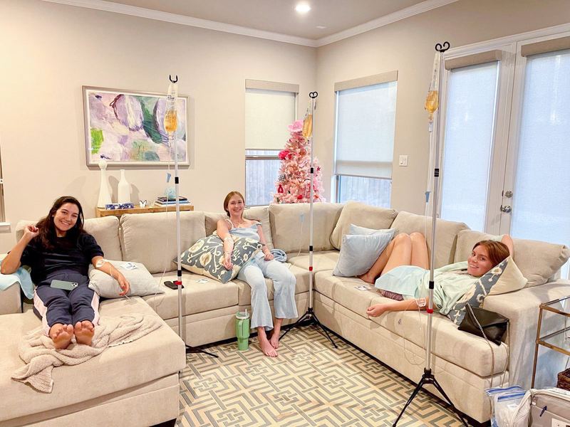 Three clients relaxing on a sectional during a group IV visit at home