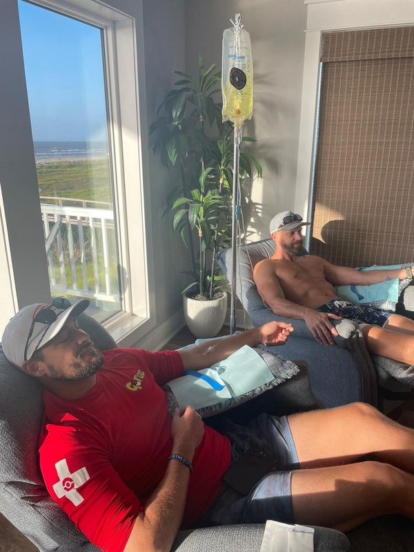 Two clients resting during their IVs in a beach house overlooking the water