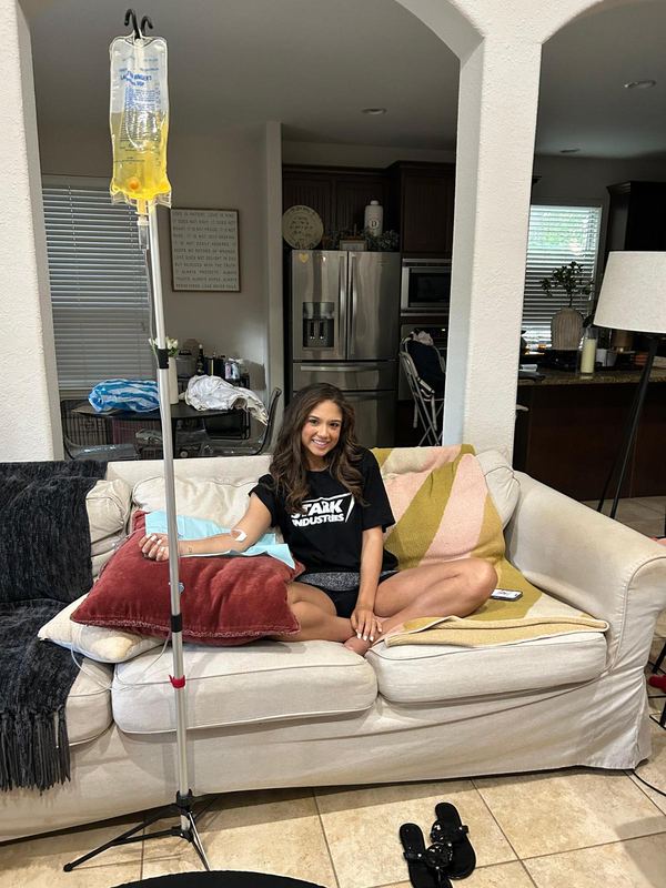 A client smiling on her couch during an in-home IV