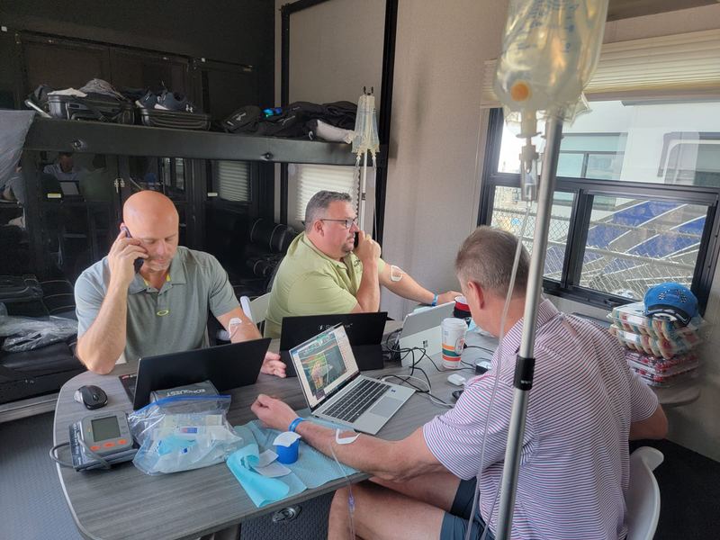 Three clients working on their laptops during their IVs at the office