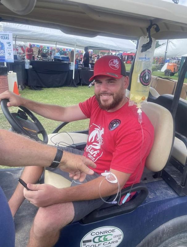 A client in a golf cart during his IV at an outdoor tournament