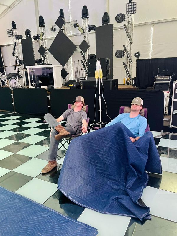 Two clients under blankets during their IVs in an event tent