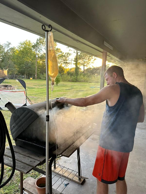 A client tending his smoker during an IV at a cook-off