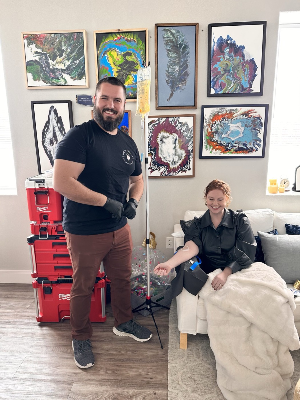 A provider standing by as a client relaxes on her couch during an in-home IV